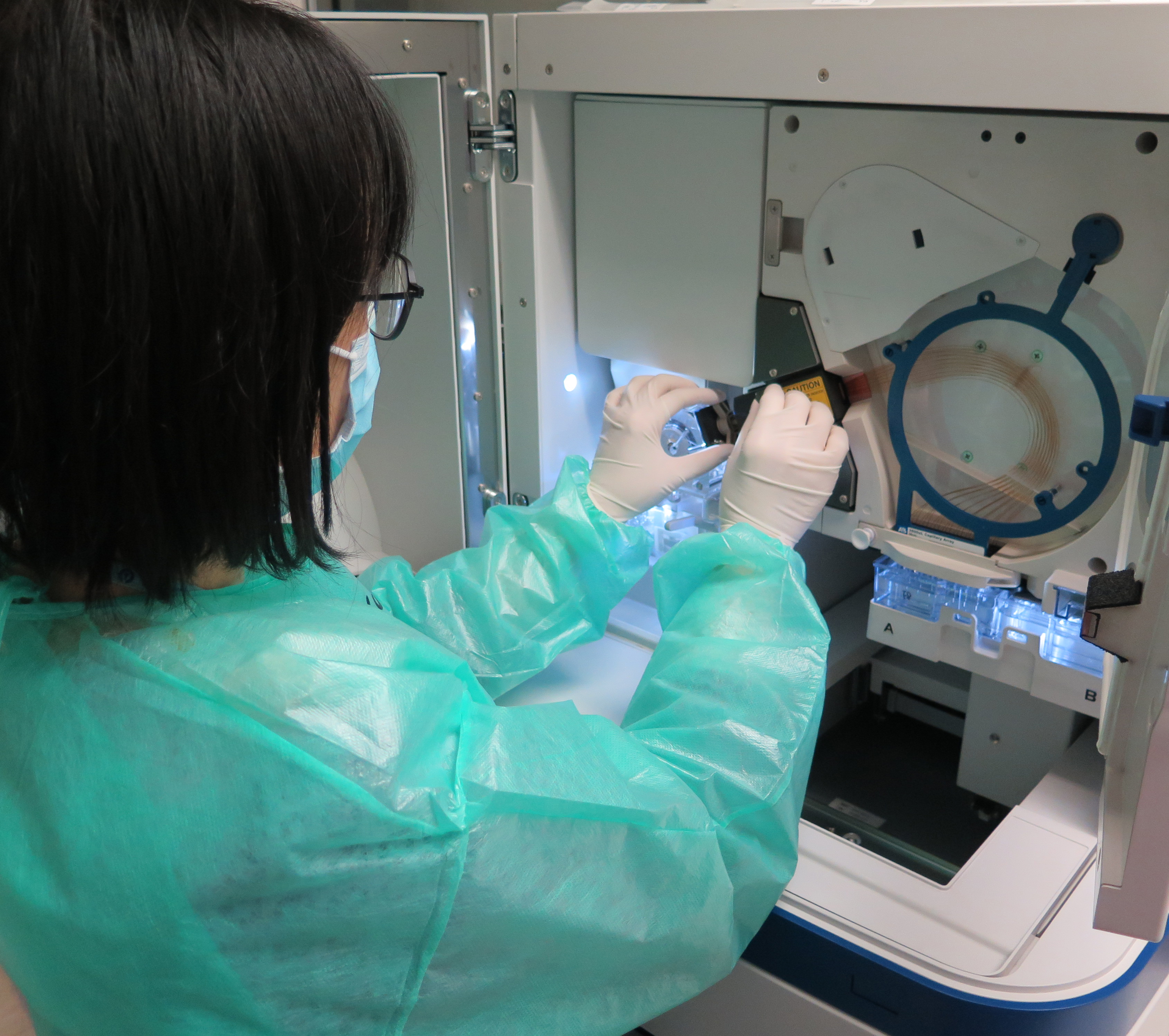 A staff is operating a genetic analyzer